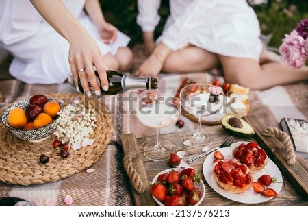 Picnic on nature. Young woman having picnic with champagne. Cakes, champagne, cheese, tomatoes. Concept, collage, dirty, fine film noise added Royalty-Free Stock Photo #2137576213