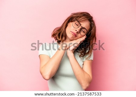 Young caucasian woman isolated on pink background yawning showing a tired gesture covering mouth with hand.
