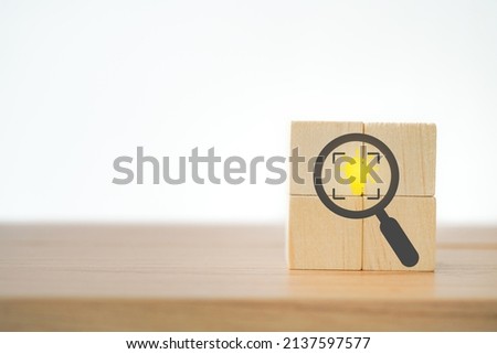 wooden cubes with magnifying glass and cropped object symbols, bright lightbulb inside with copy space Identify and clarify concept. market and customer target, focusing leadership, smart person Royalty-Free Stock Photo #2137597577