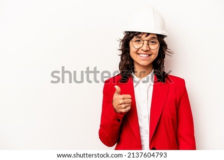 Young architect hispanic woman with helmet isolated on white background smiling and raising thumb up