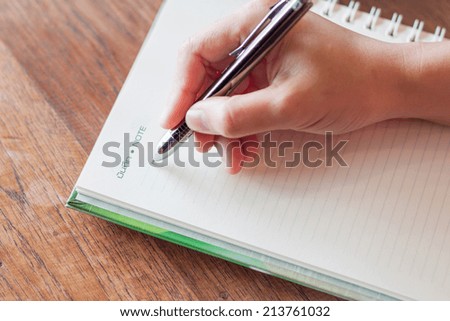 Writing important note on spiral notebook, stock photo