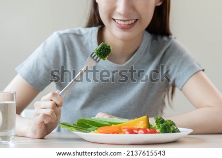 Diet, Dieting asian young woman or girl use fork at broccoli on mix vegetables, green salad bowl, eat  food is low fat good health. Nutritionist female, Weight loss for healthy person. Royalty-Free Stock Photo #2137615543