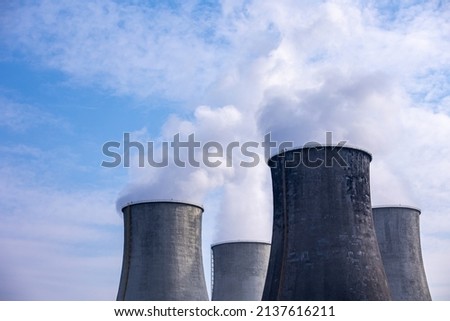 Close-up of steam coming out of the cooling towers of a coal-fired power plant. Photo taken on a sunny day, Contrast lighting. Royalty-Free Stock Photo #2137616211
