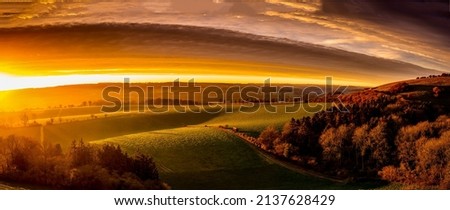 Panorama of a beautiful sunrise over the valley. Beautiful valley panorama at dawn. Sunrise over beautiful valley panoramic landscape Royalty-Free Stock Photo #2137628429