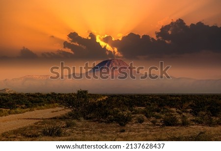A mountain in the distance in the fog of sunset. Sunset mountain peak landscape. Mountain peak at sunset Royalty-Free Stock Photo #2137628437