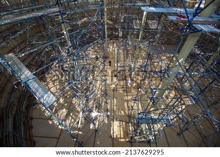 Top view Worker male assembly in progress storage tank oil inspection scaffolding work at high in confined space.