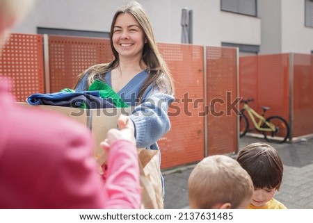 Mother of three children, Ukrainian refugee, thanking to senior woman in Europe for clothes and toys she gave to support them. Humanitarian aid and helping hand from world for Ukraine during the war Royalty-Free Stock Photo #2137631485