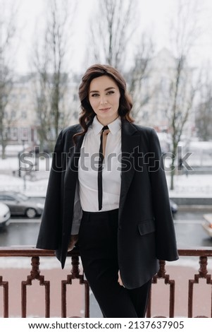  Half-length portrait of a young successful girl in a jacket on the street. High quality photo