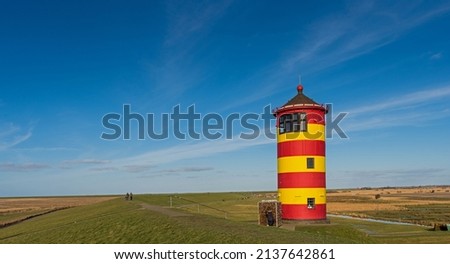 Pilsum lighthouse on the flood dam near Pilsum, East Frisia, Germany Royalty-Free Stock Photo #2137642861