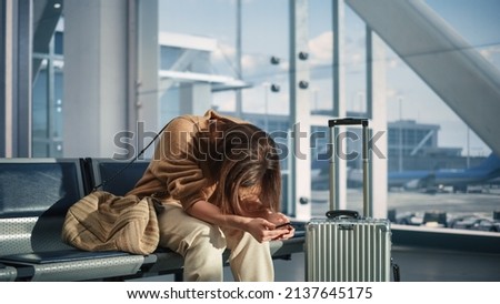 Airport Terminal: Woman Waits for Flight, Uses Smartphone, Receives Bad News, Starts Crying. Upset, Sad, and Dissappointed Person Misses Her Flight while Sitting in a Boarding Lounge of Airline Hub. Royalty-Free Stock Photo #2137645175