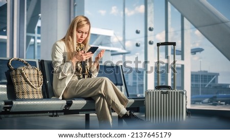 Airport Terminal: Woman Waits for Flight, Uses Smartphone, Receives Shockingly Bad News, Starts Crying. Upset, Sad, and Dissappointed Person Sitting in a Boarding Lounge of Airline Hub. Royalty-Free Stock Photo #2137645179