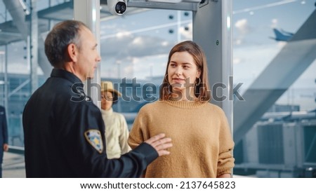Airport Terminal: Security Officer Checks and Separates Diverse Group of People Walking Through Metal Detector Scanner Gates for Plane Flight Boarding. Crowd of Travelers Going on Vacation Trips Royalty-Free Stock Photo #2137645823