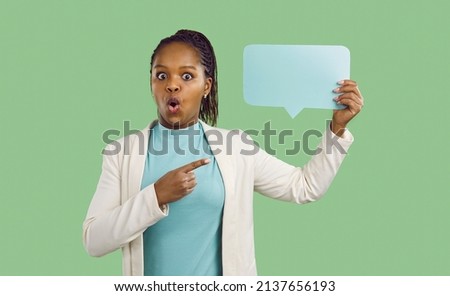 Curious adult black lady holding empty speech bubble paper card shares interesting social media message reaction, answer word, web forum conversation reply. Studio portrait, surprised face expression