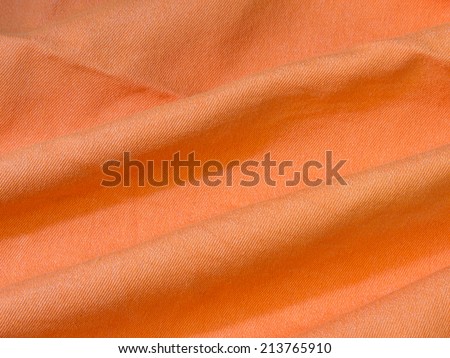 texture of bright orange fabric with folds