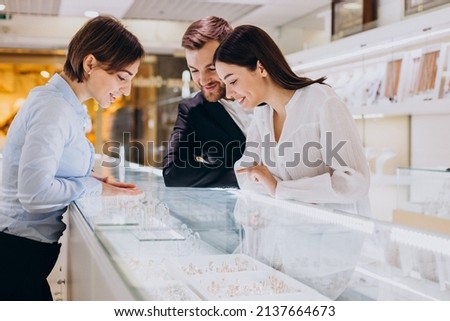 Couple at jewelry shop choosing a necklace together Royalty-Free Stock Photo #2137664673
