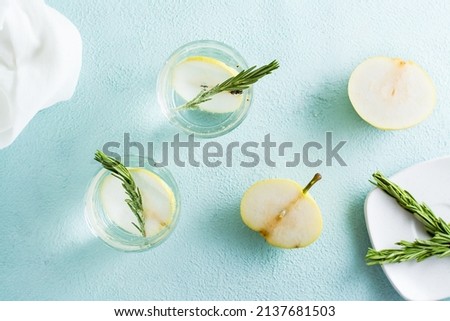 Refreshing cocktail of mineral water and pear slices in glasses on the table. Homemade drinks. Top view