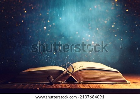 image of open antique book on wooden table with vintage key Royalty-Free Stock Photo #2137684091