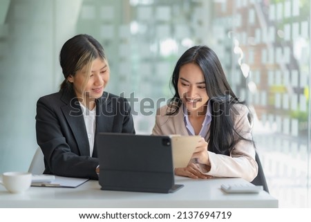 Two Asian businesswoman sitting discuss investment project working and business planning strategy at office. Royalty-Free Stock Photo #2137694719