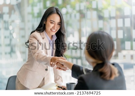 Asian businesswoman shaking hands to congratulate success. Royalty-Free Stock Photo #2137694725