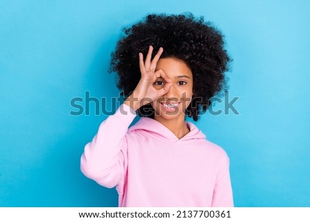 Photo of young lovely girl show fingers okey symbol see watch playful isolated over blue color background