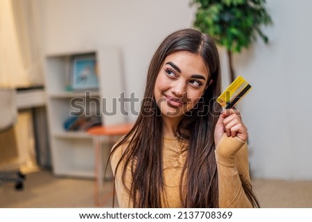 Joyful brunette girl, preparing to go shopping, while using her credit card.
