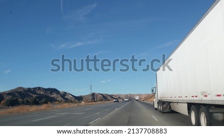 Lorry truck or semi-trailer on highway, freight cargo transportation in California USA. White container hauling or trucking on freeway road. Commercial transport logistics, van haulage. Cars driving. Royalty-Free Stock Photo #2137708883