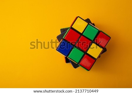 Bright rubik's cube on a yellow background Royalty-Free Stock Photo #2137710449