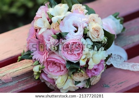 wedding bouquet consists of white, pink, purple flowers, green leaves, gerbera flowers, peony roses on old wooden background with peeling red paint, beautiful and colorful bouquet of flowers