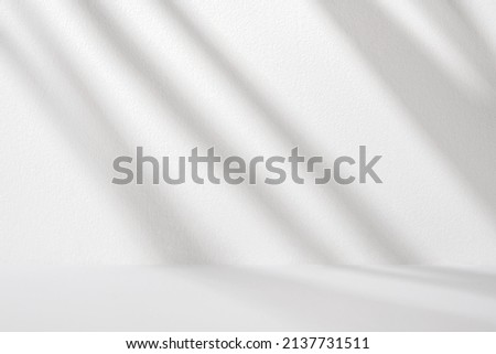 White wall and table with diagonal light and shadows for product presentation. Abstract gradient background in the room. Royalty-Free Stock Photo #2137731511