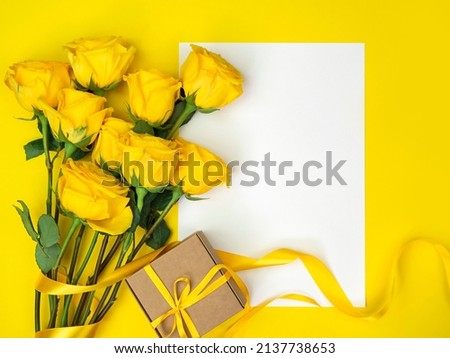 Bouquet of yellow roses on yellow background with space for text.