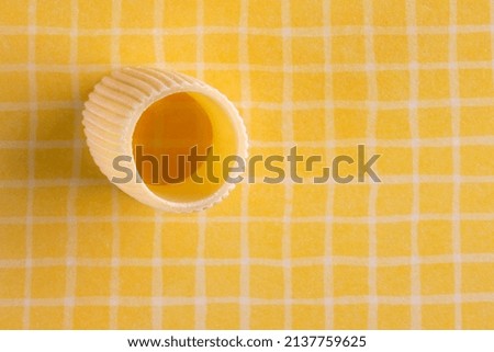 Uncooked pasta on yellow checkered background isolated macro