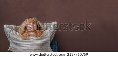 middle-aged woman resting relaxed on the terrace sofa