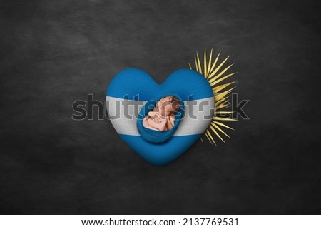 Newborn portrait on heart in color of national flag. Photography peace concept. El Salvador