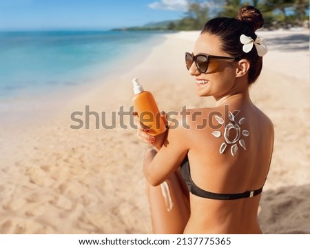 Beauty Woman Applying Sun Cream on Tanned Shoulder In Form Of The Sun. Sun Protection.Sun Cream. Skin and Body Care. Girl Using Sunscreen to Skin. Female Holding Suntan Lotion Royalty-Free Stock Photo #2137775365