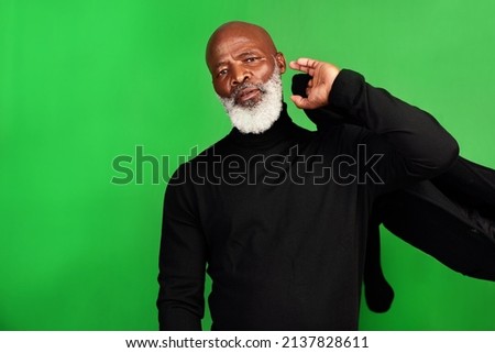 Ill never grow tired of dressing up. Studio shot of a senior man posing against a green background.