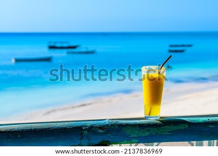 Juice of pineapple and orange. Ocean at background