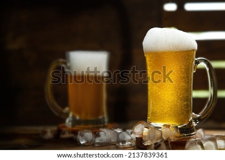 fresh beer with bubbles in a glass mug over dark wooden background in a pub or bar. High quality photo