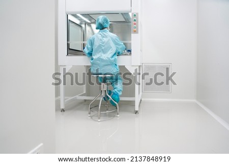 Unidentified microbiologist is testing the sample under the laminar air flow cabinet in the clean room of quality control laboratory in pharmaceutical industry. Royalty-Free Stock Photo #2137848919