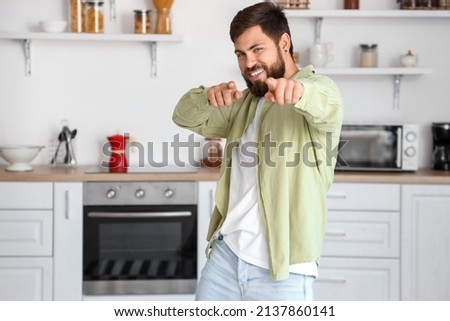 Handsome man dancing in kitchen