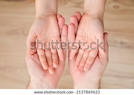 Kids hands in the fathers palms. Parenting, friendship, guardianship, upbringing, parent-child relationship, family connection. Royalty-Free Stock Photo #2137869623