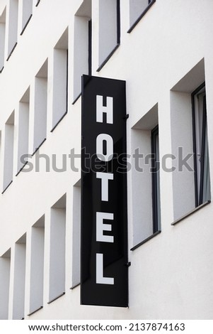 vertical hotel sign on generic modern city hotel building facade