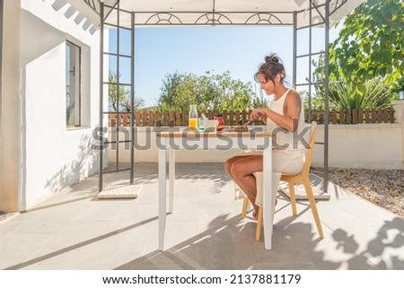 woman having breakfast on the patio of her rural house