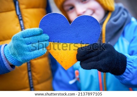 Picture of a child with a lot of love and peaceful message holding heart