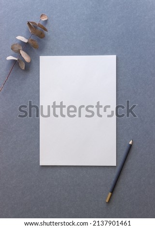 White paper and pencil on a gray background. Design. Mock up. Copy space