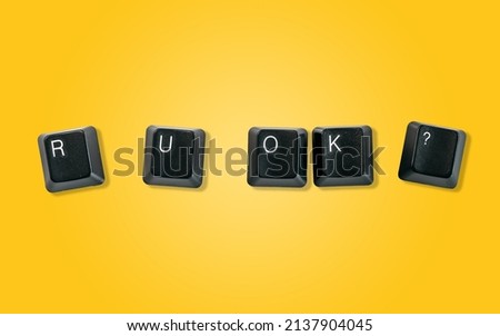 Computer keyboard keys spelling R U OK?, isolated on a yellow background Royalty-Free Stock Photo #2137904045