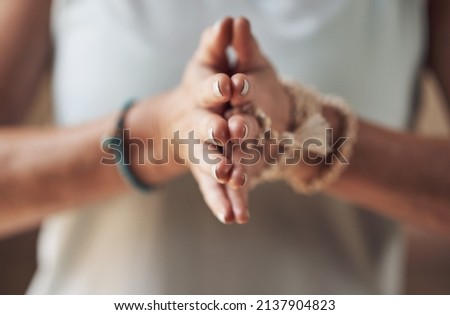 Balancing my chakras. Cropped shot of an unrecognizable woman standing with her palms together while meditating indoors. Royalty-Free Stock Photo #2137904823