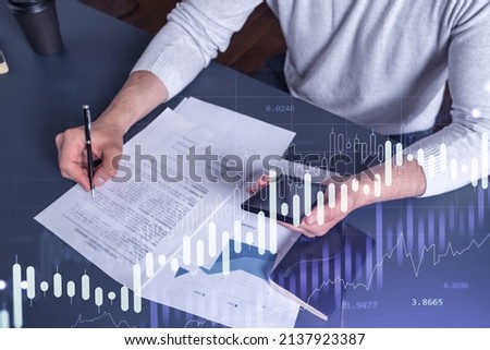 A client in casual wear is signing the contract to invest money in stock market. Internet trading and wealth management concept. Checking the details of transaction at smart phone.