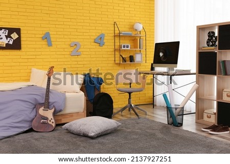 Stylish teenager's room interior with computer and bed Royalty-Free Stock Photo #2137927251