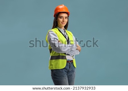Young female site engineer with a safety vest and hardhat isolated on blue background Royalty-Free Stock Photo #2137932933