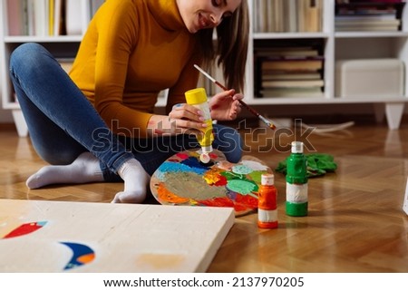 woman painting picture at home